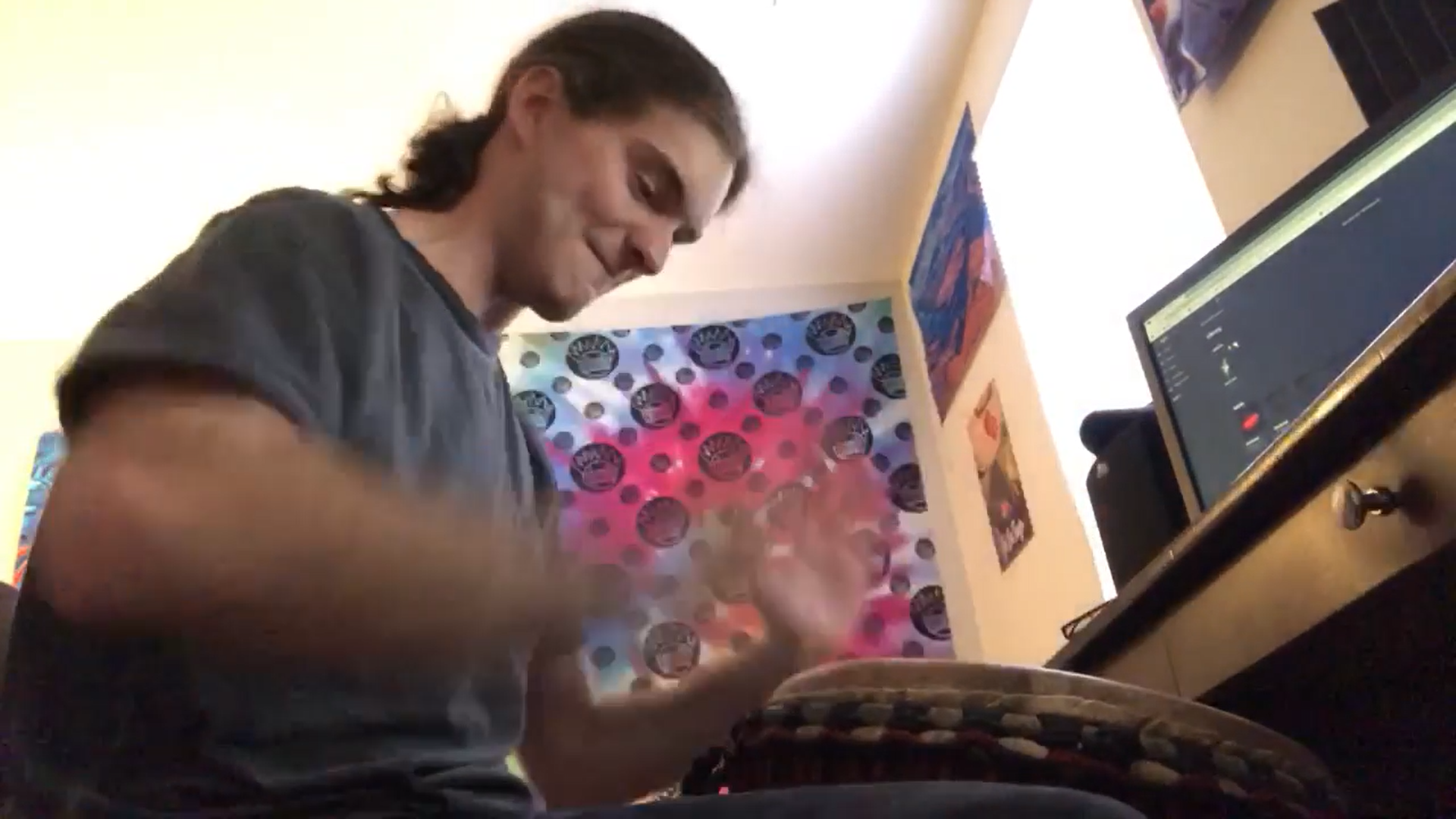 RIT student Stephen Greene practices rhythm patterns on a djembe drum from his home. Photo supplied by Stephen Greene.